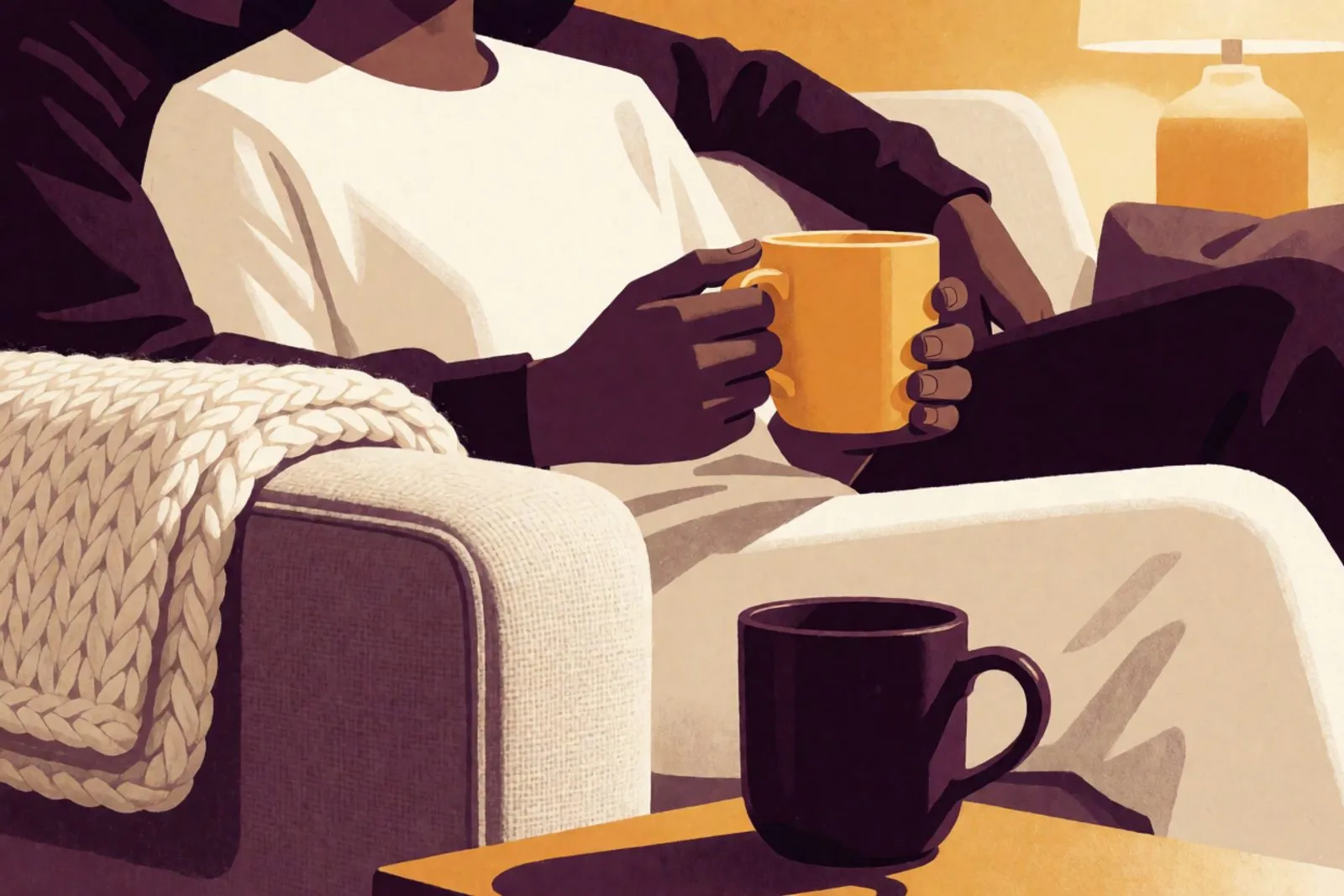 Two mugs and a folded blanket on a couch in the evening, a hand resting next to another hand.